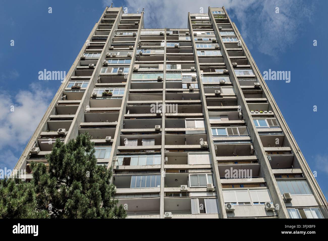Blick nach oben zu einem typischen Hochhaus-Wohnblock mit zahlreichen Balkonen und Klimaanlagen, Belgrad, Serbien Stockfoto