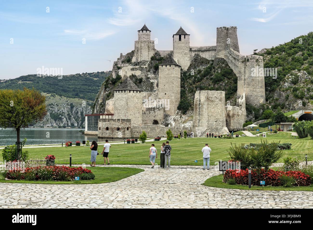 Besucher spazieren in der Nähe der historischen Festung Golubac entlang der Donau in Serbien. Stockfoto