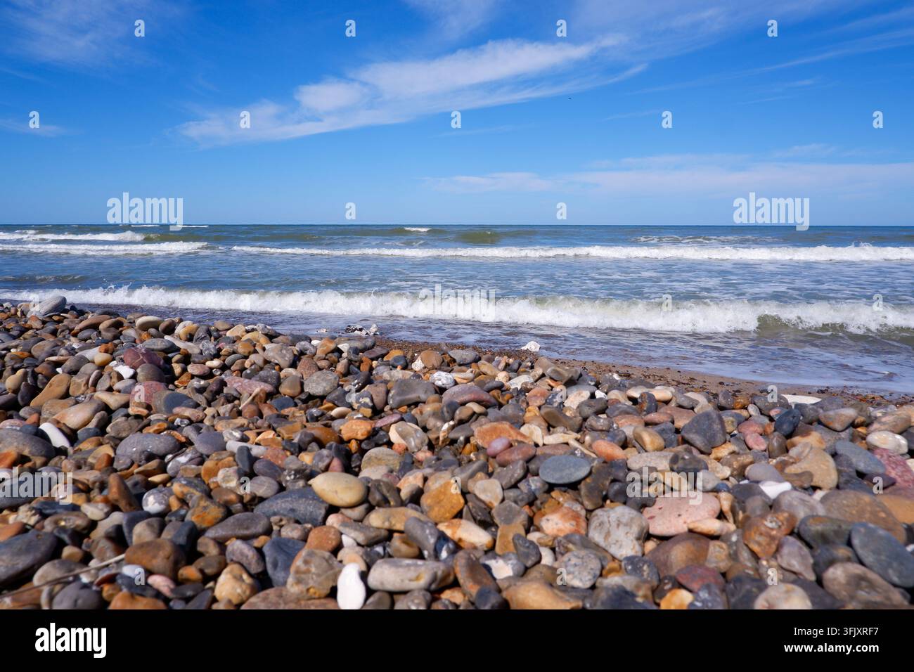 Steinküste der Nordsee aus kleinen Kopfsteinpflastersteinen. Steine am Strand. Kieselsteine an der Küste. Stockfoto