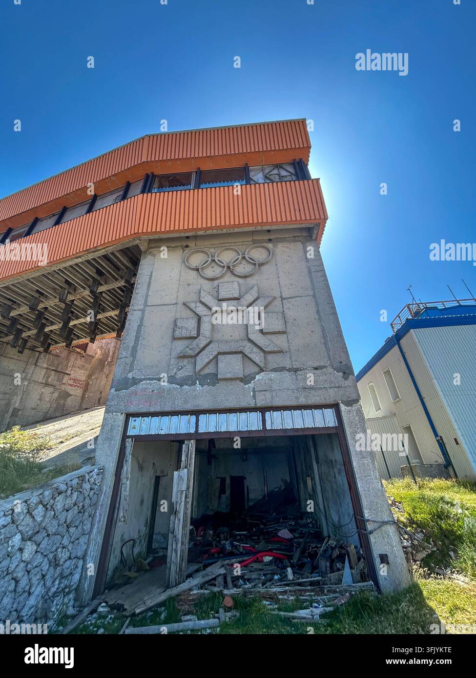 Verwittertes Betongebäude mit Relief der Olympischen Ringe, ehemaliger Start der Abfahrt der Winterolympiade 1984 auf Bjelašnica, Bosnien - Smartphone-aufgenommenes Stockfoto