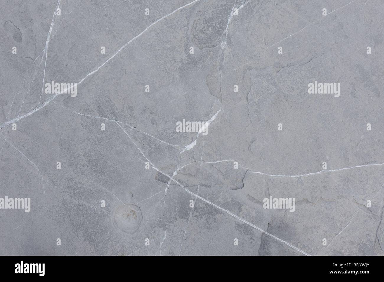 Graue Schieferstein-Bodenstruktur mit Sneaker-Detail Stockfoto