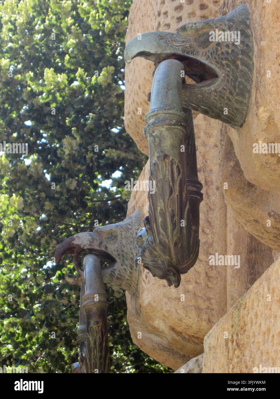 Bronzeringe mit Adlerköpfen, die an einer behauenen Steinmauer verankert sind, zum Anbinden von Pferden an der Fassade der Alhambra, Palast von Karl V, Granada. Stockfoto