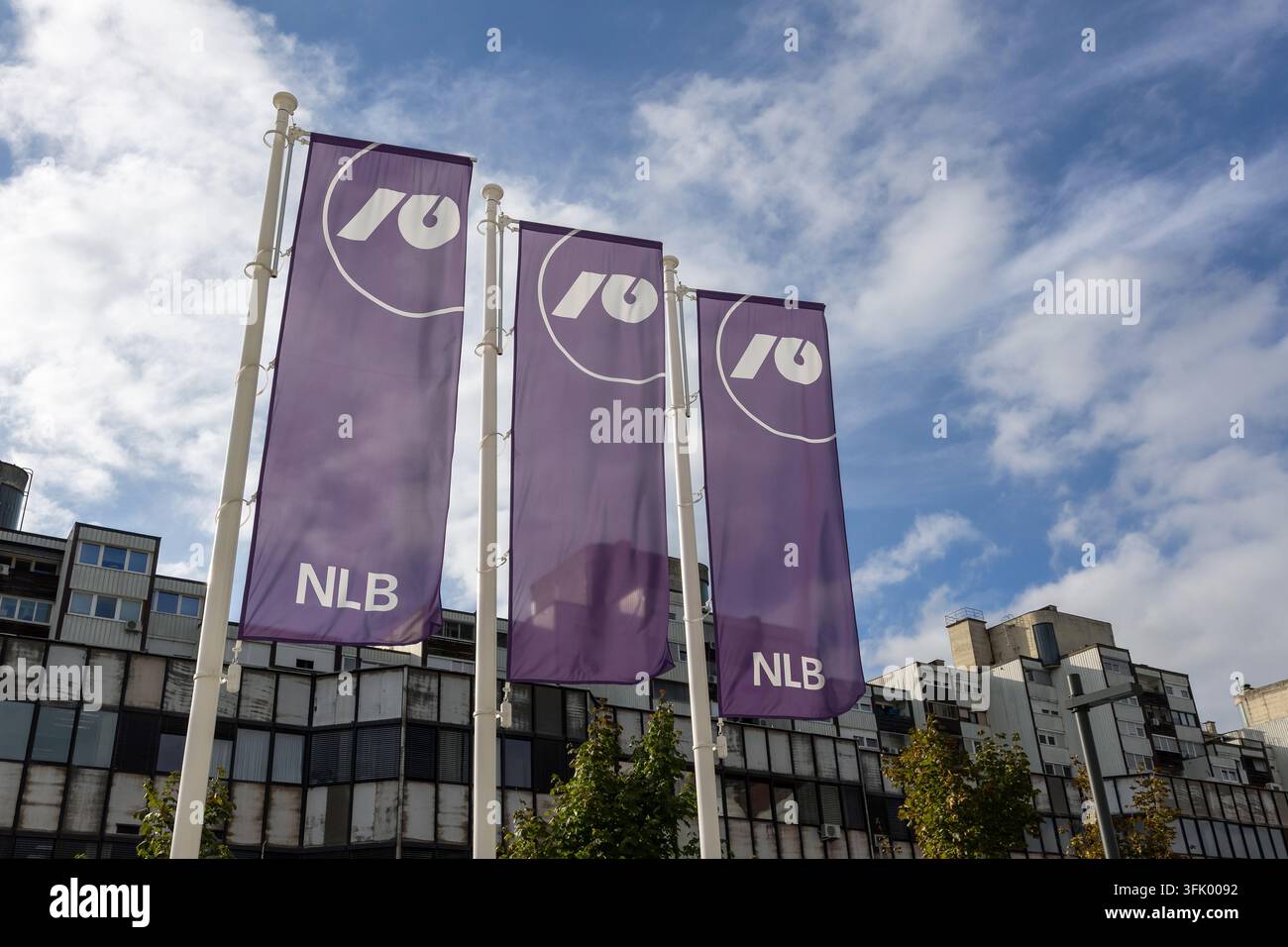 Ljubljana, Slowenien - 21. September 2026: Flaggen der NLB-Bank sind mit Gebäuden im Hintergrund und blauem Himmel zu sehen. Stockfoto