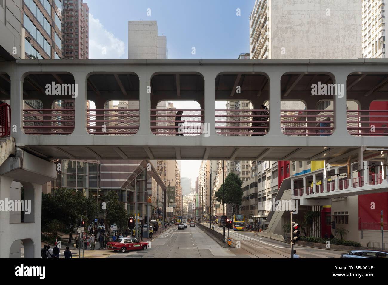Fußgänger überqueren die Überführung über die King's Road in North Point, Hongkong, um sicher die belebte Straße darunter zu überqueren. Stockfoto