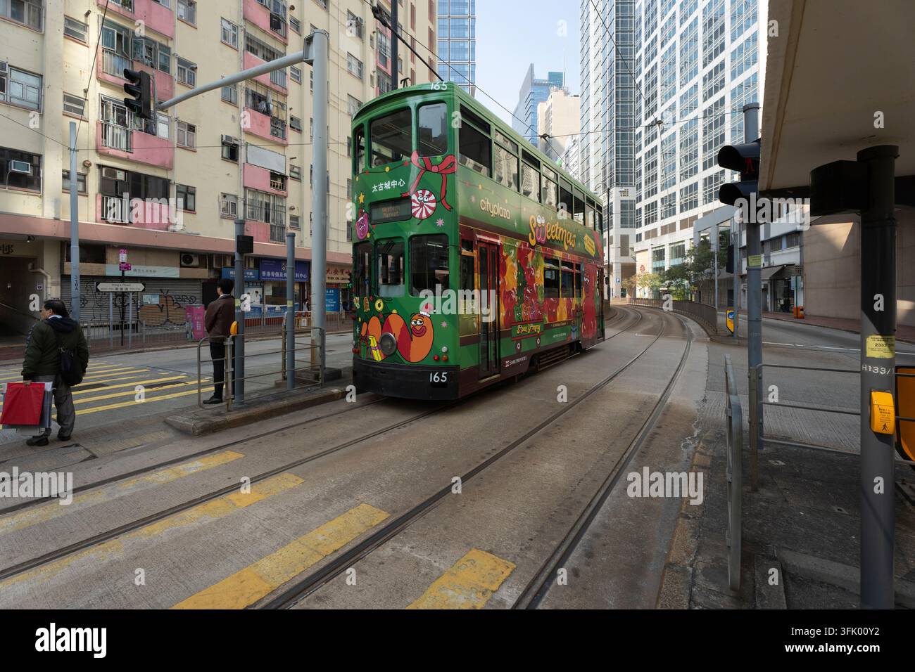Eine festliche "Sweetmas"-Straßenbahn fährt den King's Road in North Point, Hongkong, und bringt Passagiere an Weihnachten vorbei an Wolkenkratzern vorbei. Stockfoto