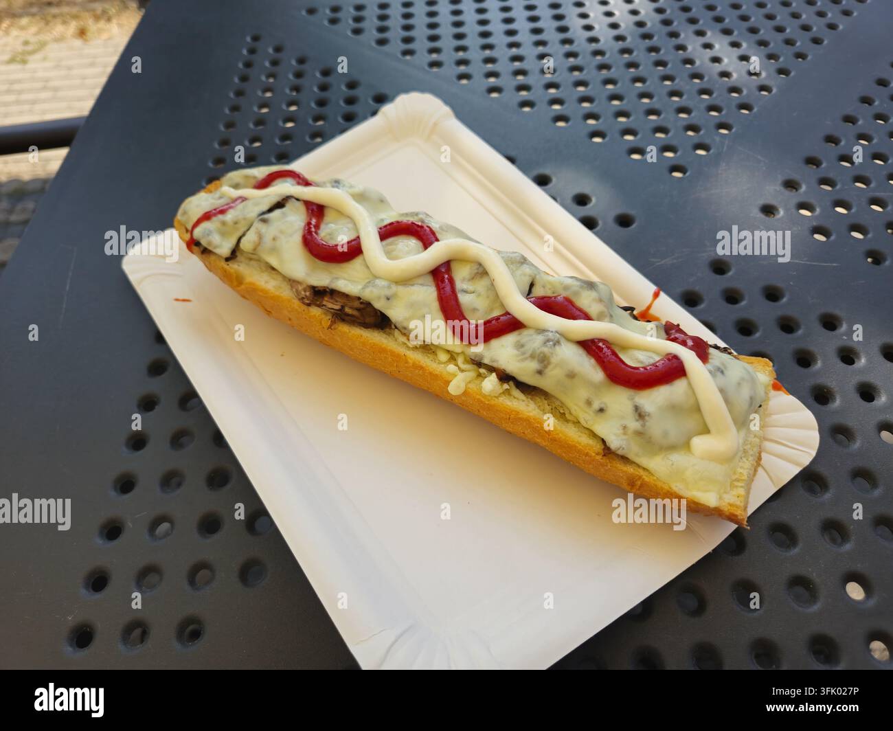 Polnische traditionelle Zapiekanka. Heiße geschnittene Baguette mit Pilzen und Käse. Stockfoto