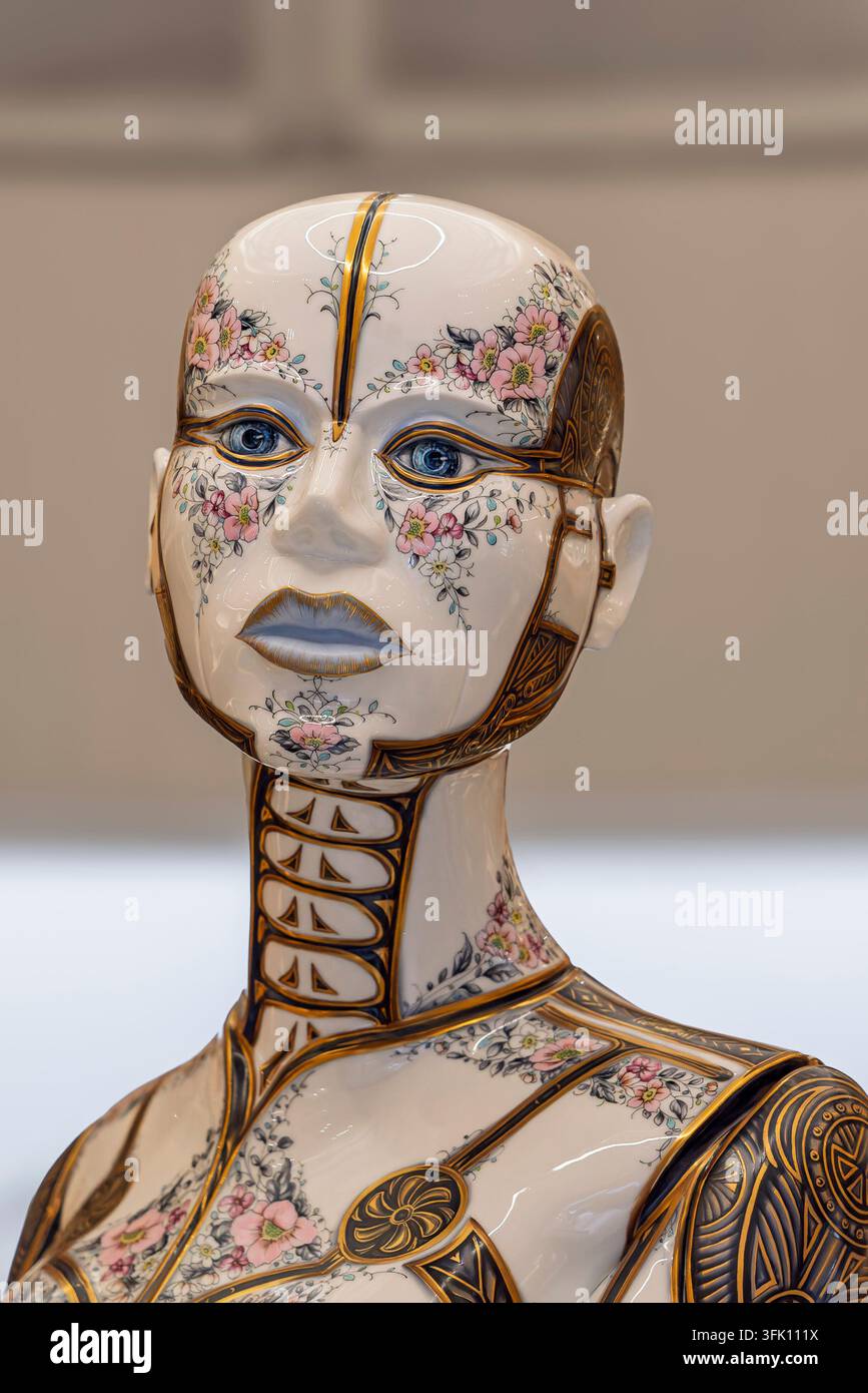 Zarte rosa und weiße Blumenpinsel bedecken das glatte Porzellangesicht der Herend-Schönheit-oder-das-Monster-Skulptur, ihre stilisierten Augen und die vergoldete Naht l Stockfoto