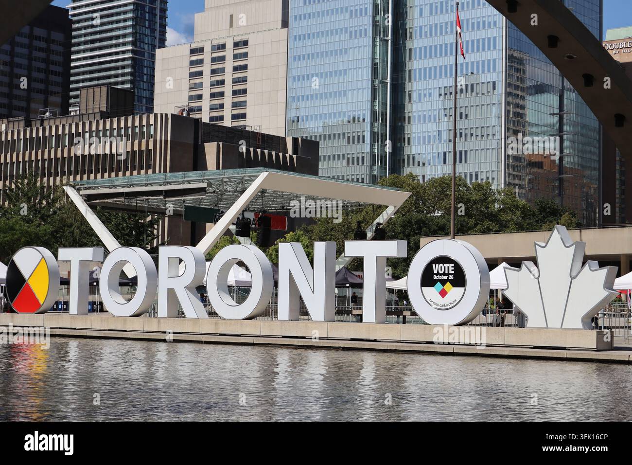 Das Toronto-Schild mit seinem Ahornblatt am Nathan-Phillips-Platz, mit den Hochhäusern der Innenstadt im Hintergrund, Toronto, Ontario, Kanada. Stockfoto
