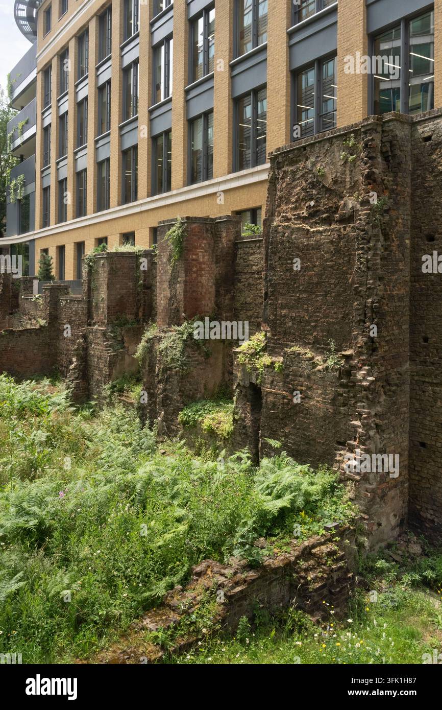Alte römische und mittelalterliche Überreste der Londoner Mauer an der Noble Street sind neben modernen Büros erhalten, um das Erbe der Stadt zu ehren. Stockfoto