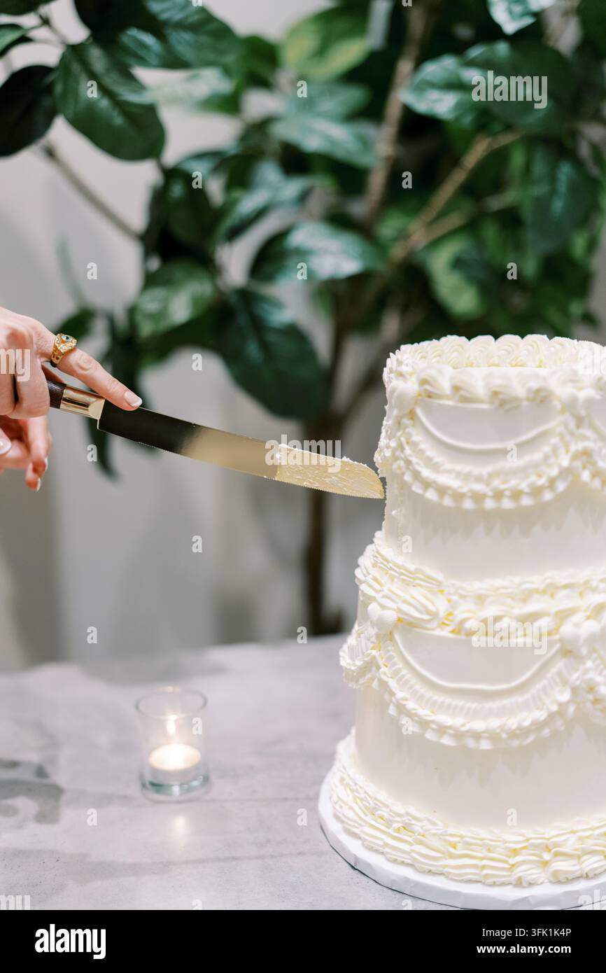 Elegante dreistöckige Hochzeitstortenschneidezeremonie Stockfoto