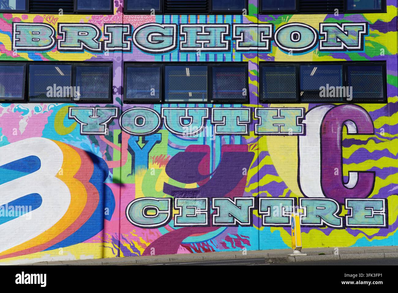 Brighton Youth Centre in großen bunten Buchstaben auf einer mit Wandmalereien bedeckten Gebäudefassade in Brighton, England, gemalt. Stockfoto