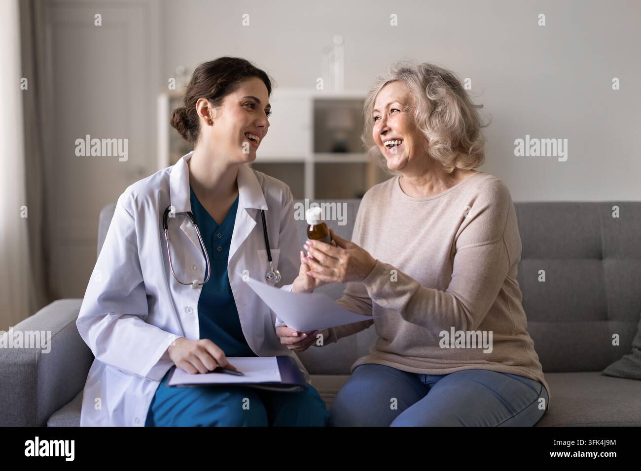 Arzt verschreibt Pillen und gibt der älteren Patientin eine Medikamentenflasche Stockfoto