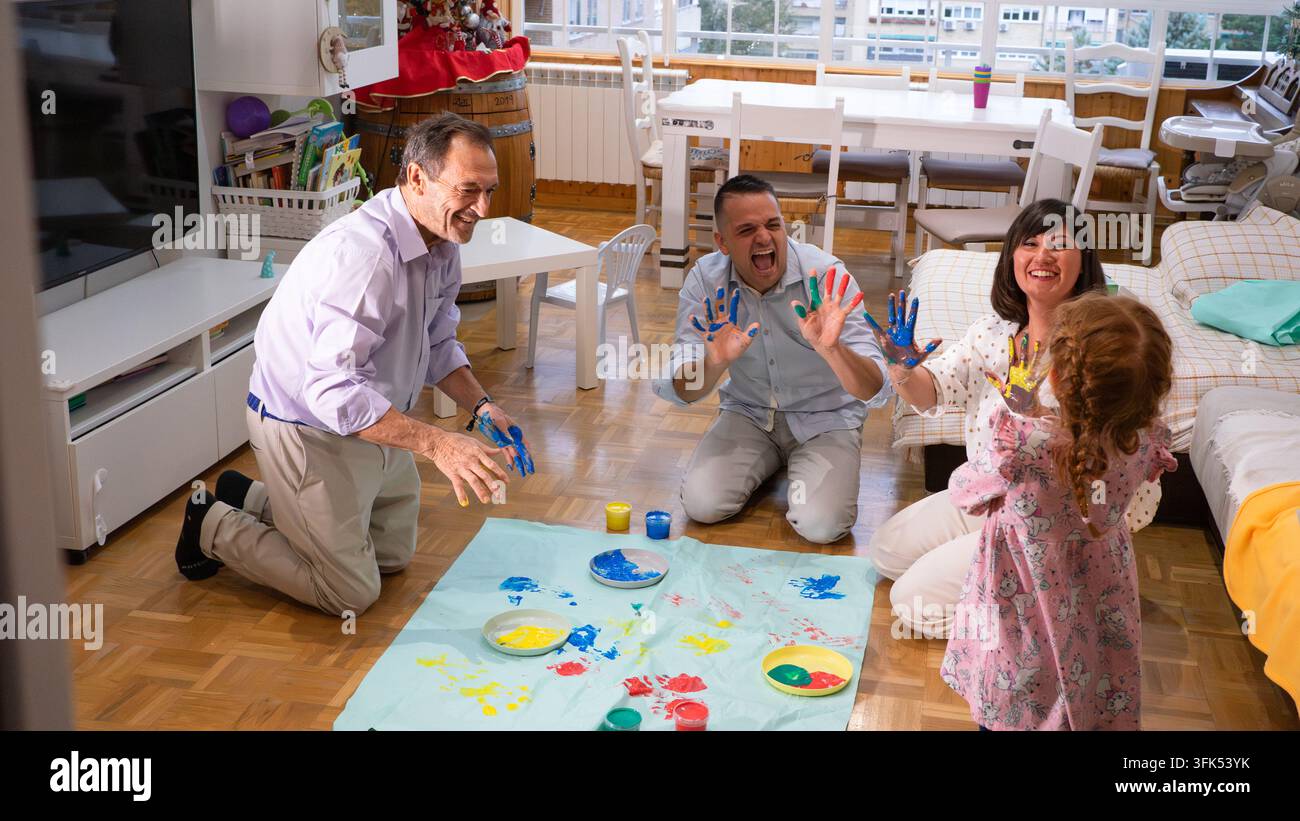 Mehrgenerationen-Familie genießt schmutzige Finger beim gemeinsamen Malen zu Hause Stockfoto