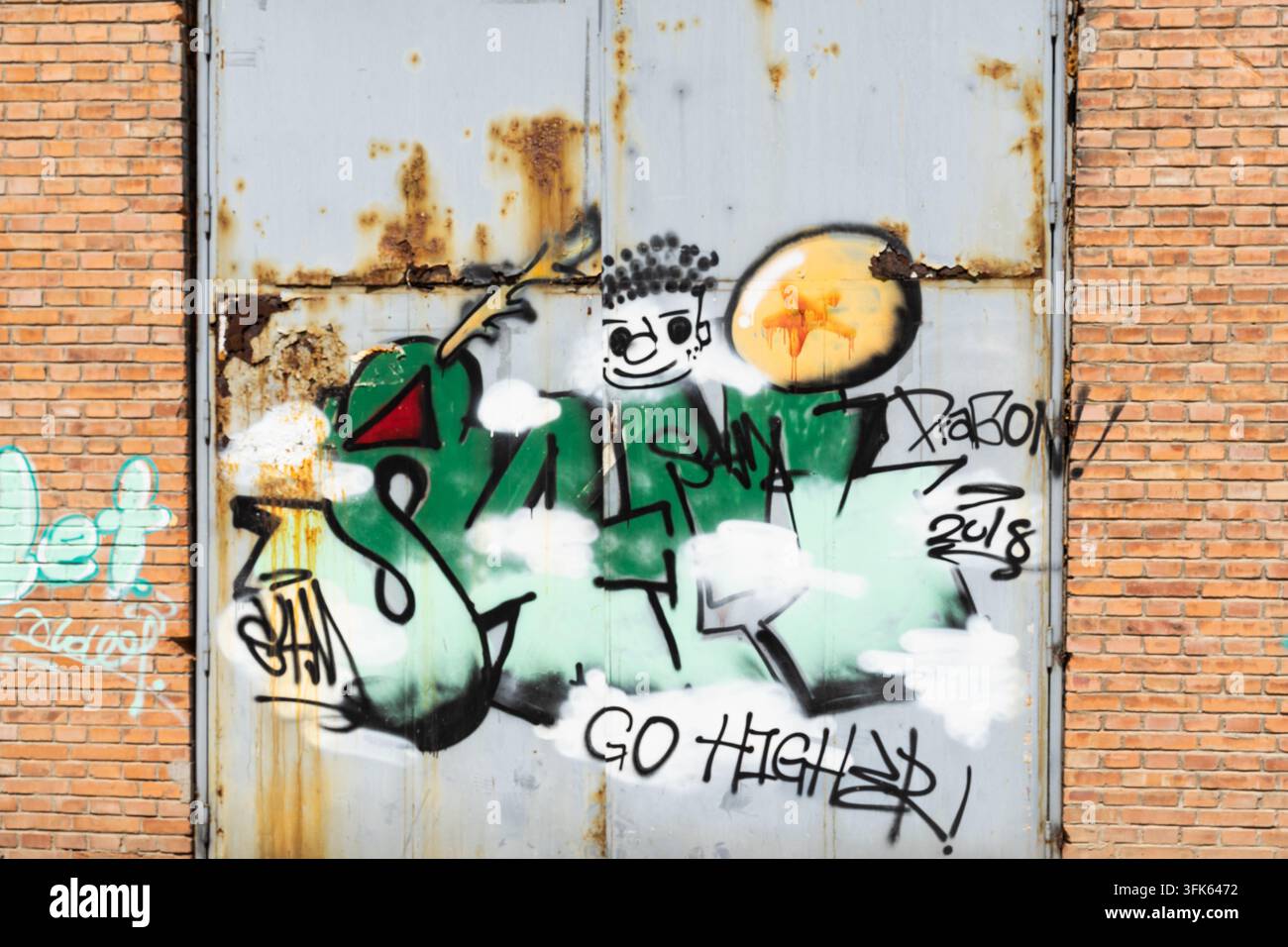 Cartoon-Graffiti an einem rostigen Metalltor im Kunstviertel 798 in Peking Stockfoto