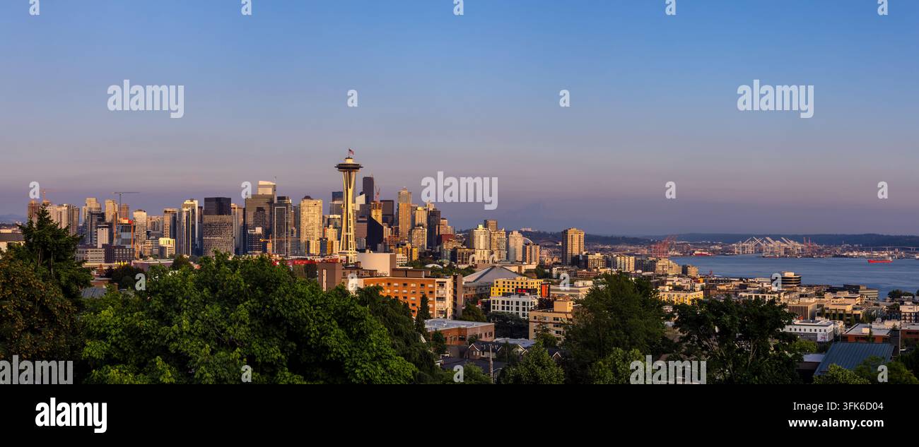 Blick auf die Space Needle und die Innenstadt von Seattle mit Ufergebäuden und üppigen Bäumen unter einem klaren blauen Himmel in Seattle, Washington, Einheit Stockfoto