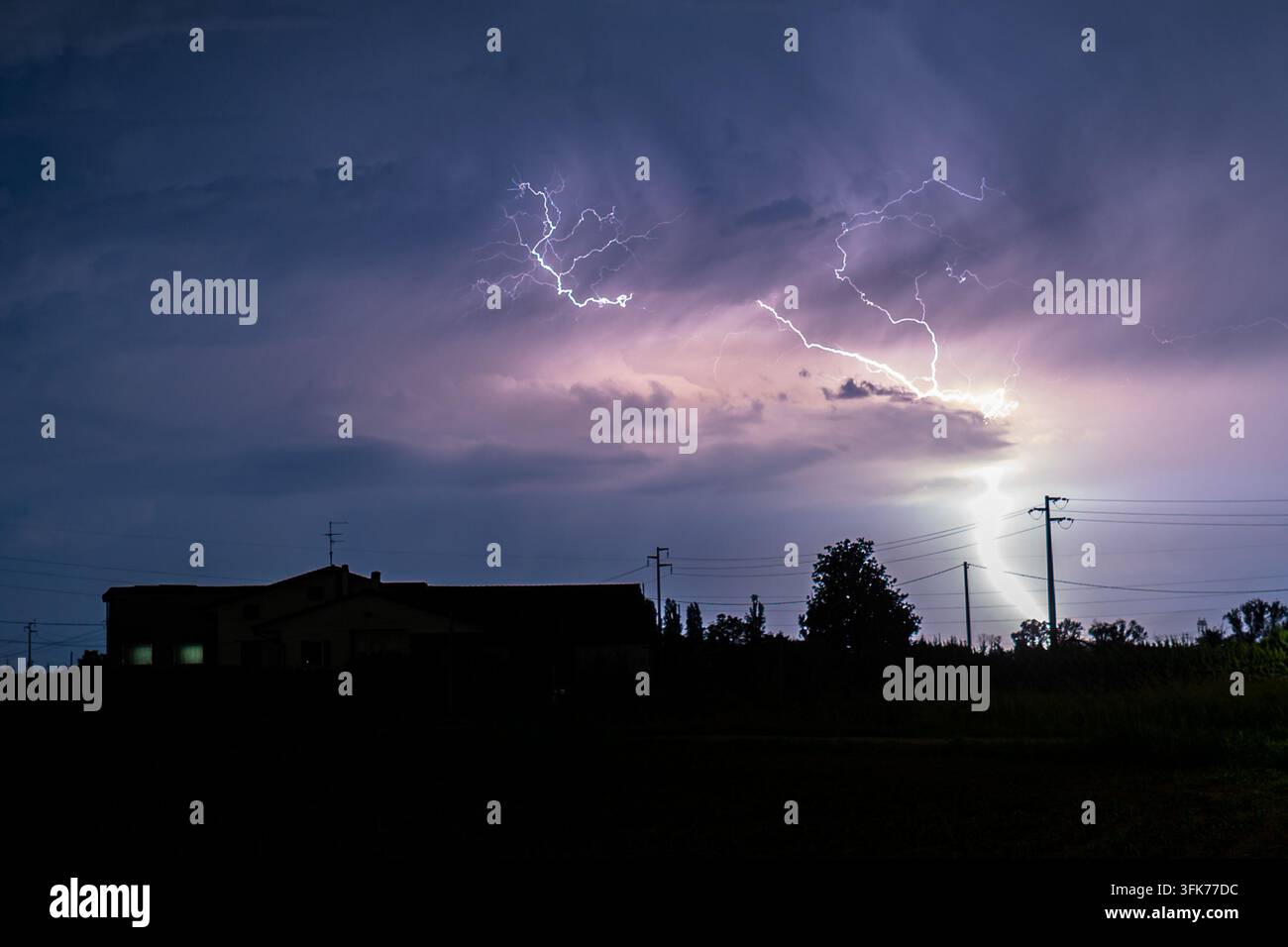 Ein heller Blitz schlägt in der Nähe einer Ranch im Po-Tal im Norden Italiens in den Boden ein. Stockfoto