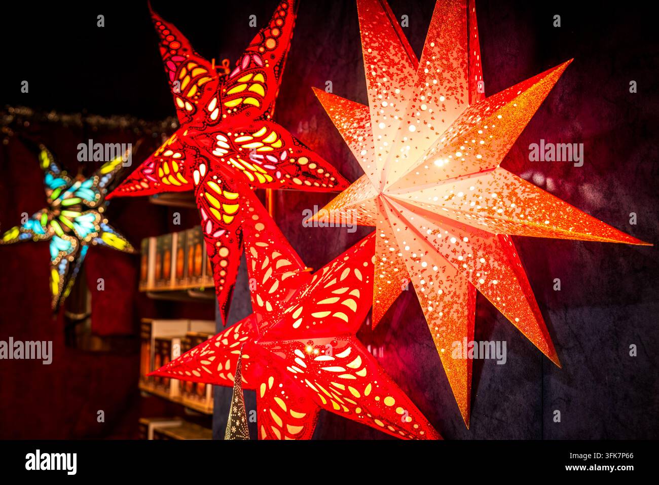 Heftig leuchtende rote Papiersternlaternen auf dem Weihnachtsmarkt in Wien, Österreich Stockfoto