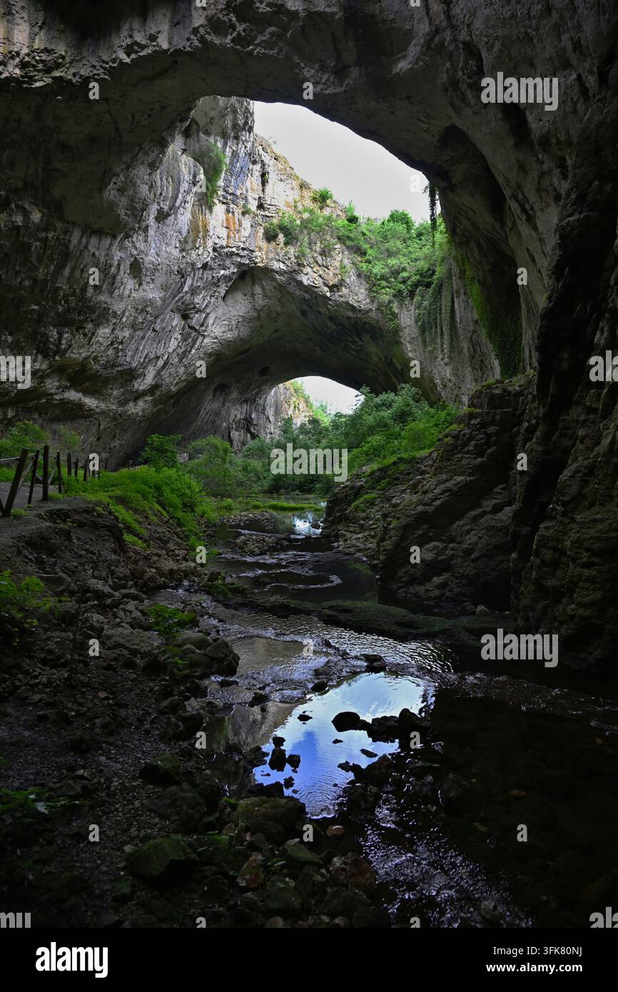 Höhle mit mehreren Bögen und üppiger Vegetation entlang eines felsigen Pfades, Gabrovo, Bulgarien Stockfoto