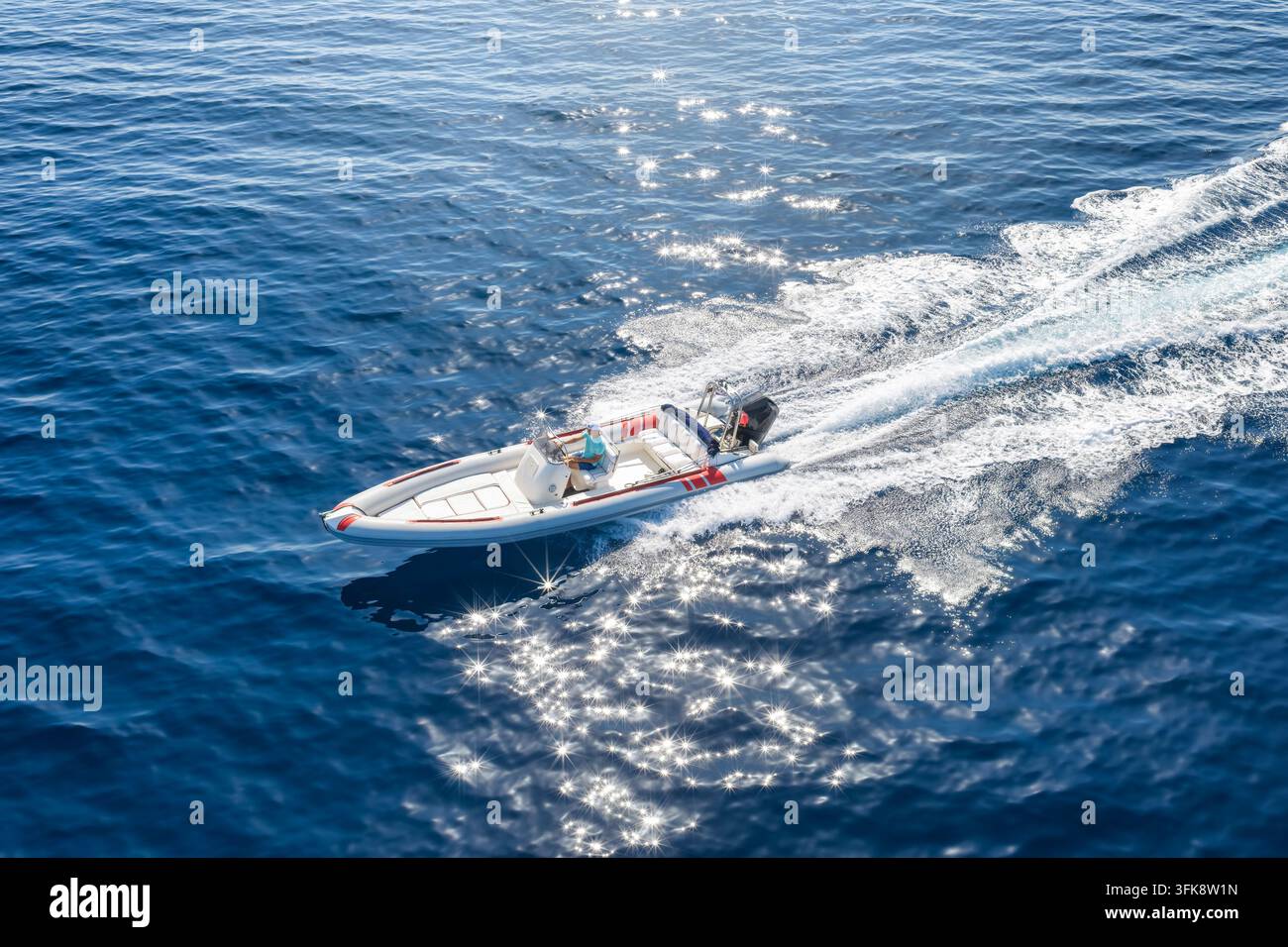 Luftaufnahme von oben eines RIB-Motorboots mit Außenbordmotor, das mit hoher Geschwindigkeit über den Ozean gleitet Stockfoto