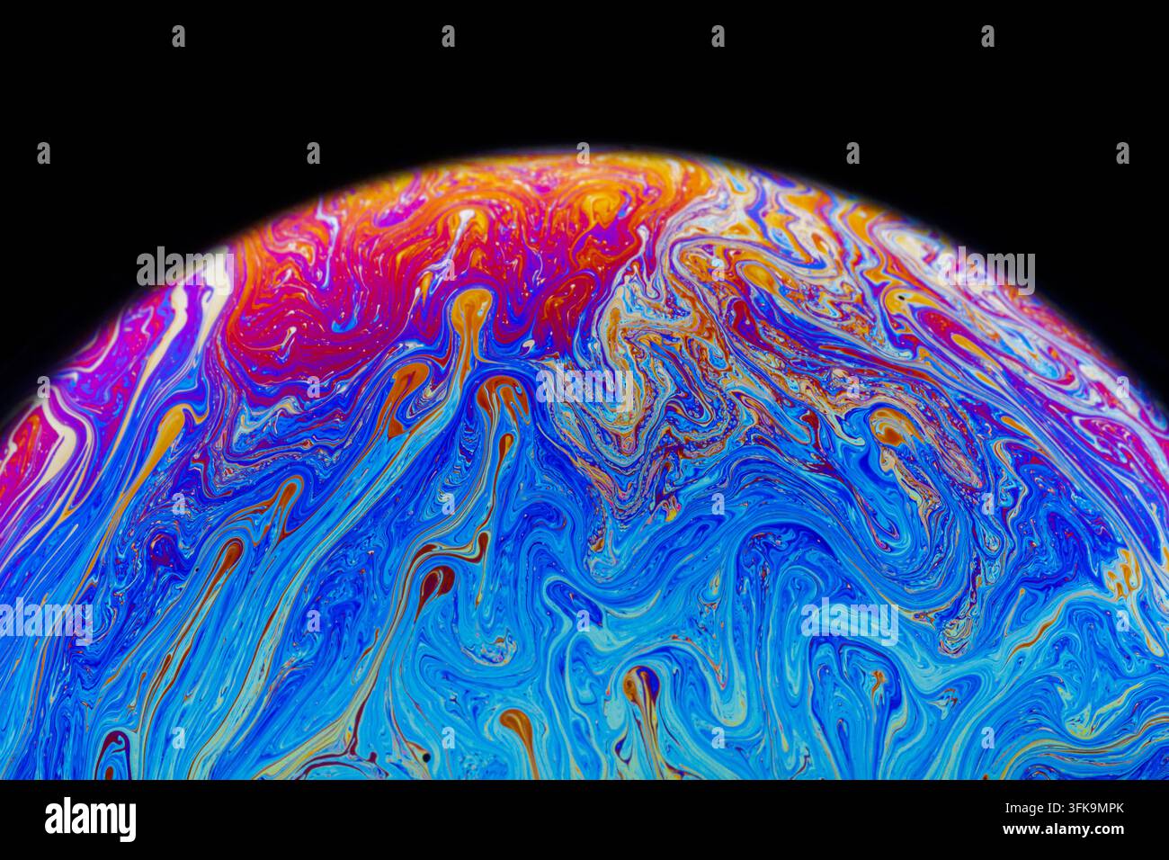 Nahaufnahme einer farbenfrohen Seifenblase, die irisierende Muster, Farben und Formen zeigt, die durch dünne Filminterferenzen verursacht werden Stockfoto