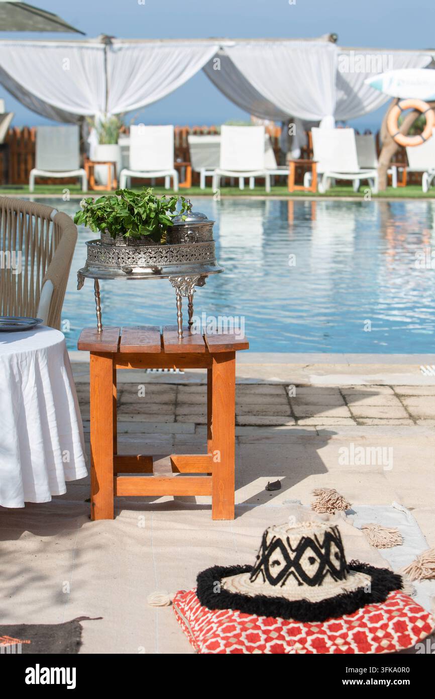 Traditionelles marokkanisches Minztee-Setup neben einem Swimmingpool in einem Luxusresort. Eine traditionelle marokkanische Minztee-Zubereitungsausstattung neben einem Hotel Stockfoto
