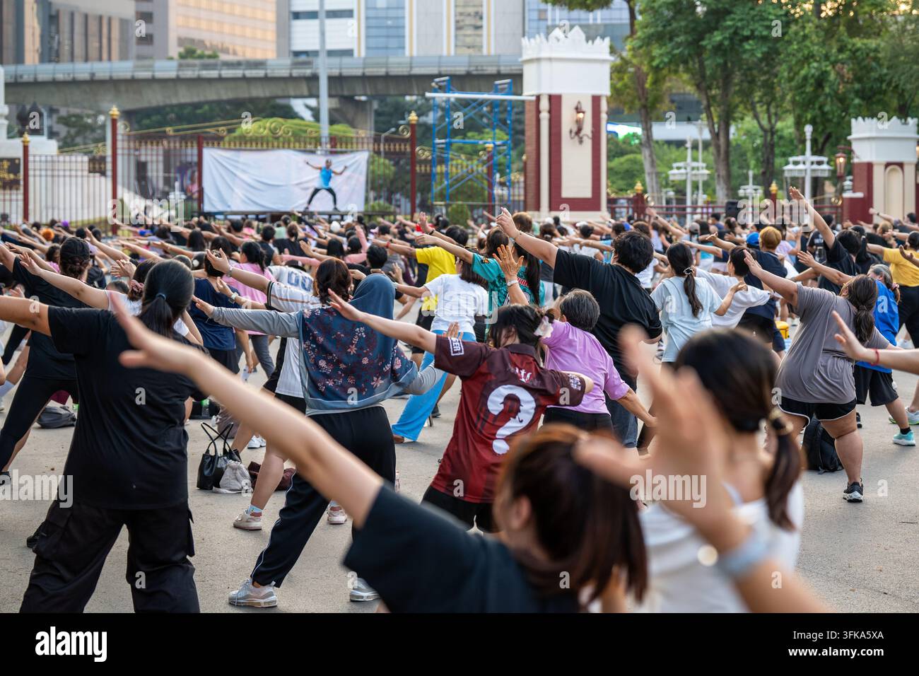 Einheimische trainieren im Freien auf dem Platz im Lumpini-Park in Bangkok bei einem kostenlosen Massengruppentraining. Stockfoto