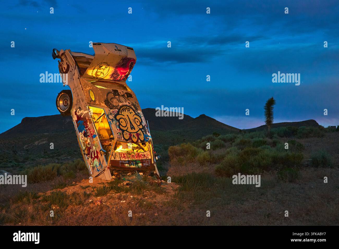 Verlassenes Graffiti-Auto in der Nacht in der Nevada-Wüste Internationaler Autoforest Lichtmalerei Stockfoto