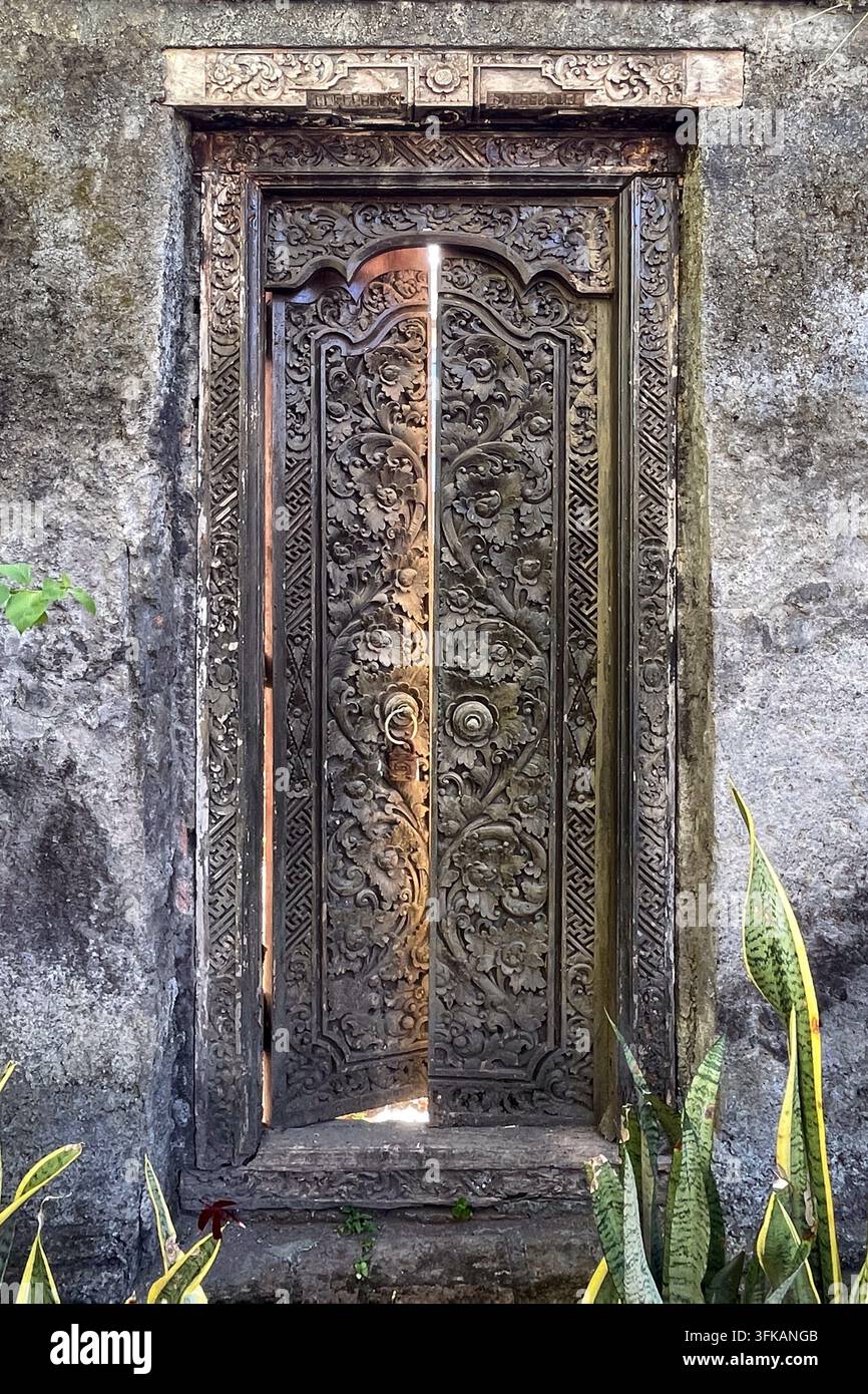 Traditionelle geschnitzte balinesische Eingangstür in einem Hotel in Bali, Indonesien, am 13. April 2026 Stockfoto