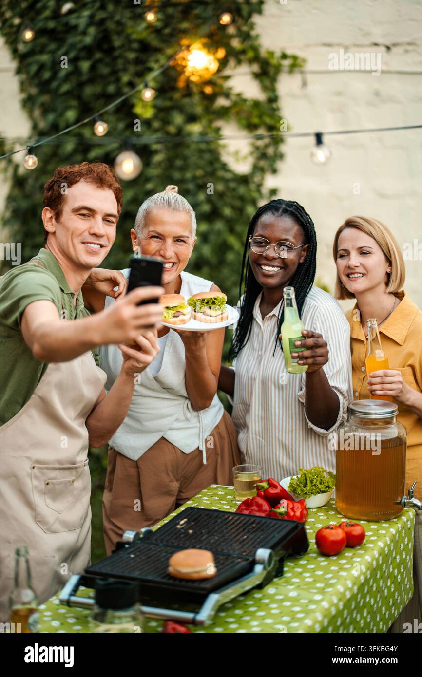 Verschiedene Freunde machen ein Selfie während einer Grillparty im Hinterhof Stockfoto