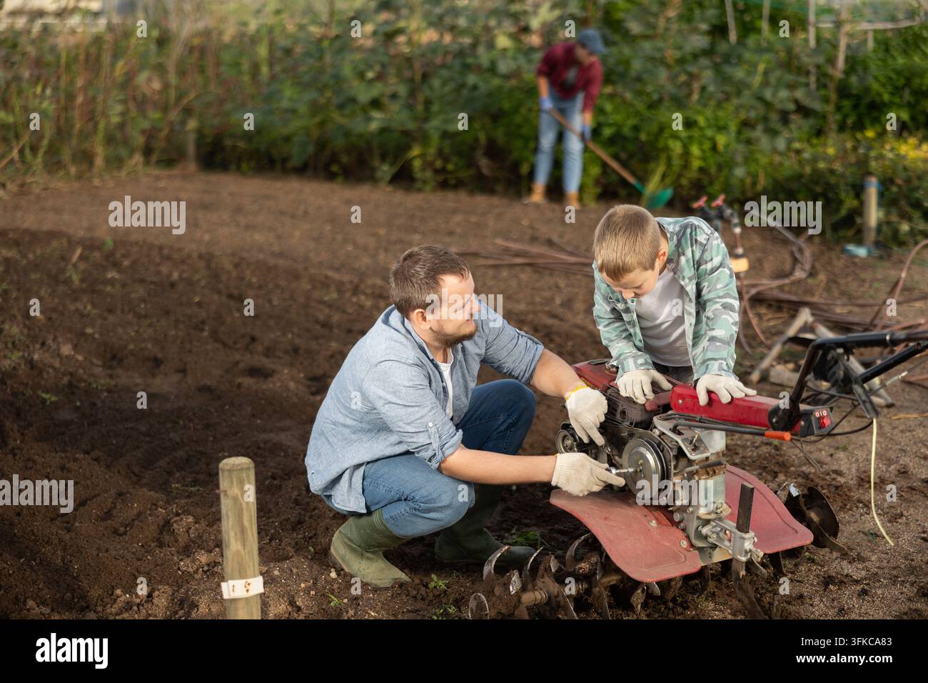 Der Mann und sein Sohn reparieren Gartengeräte Stockfoto