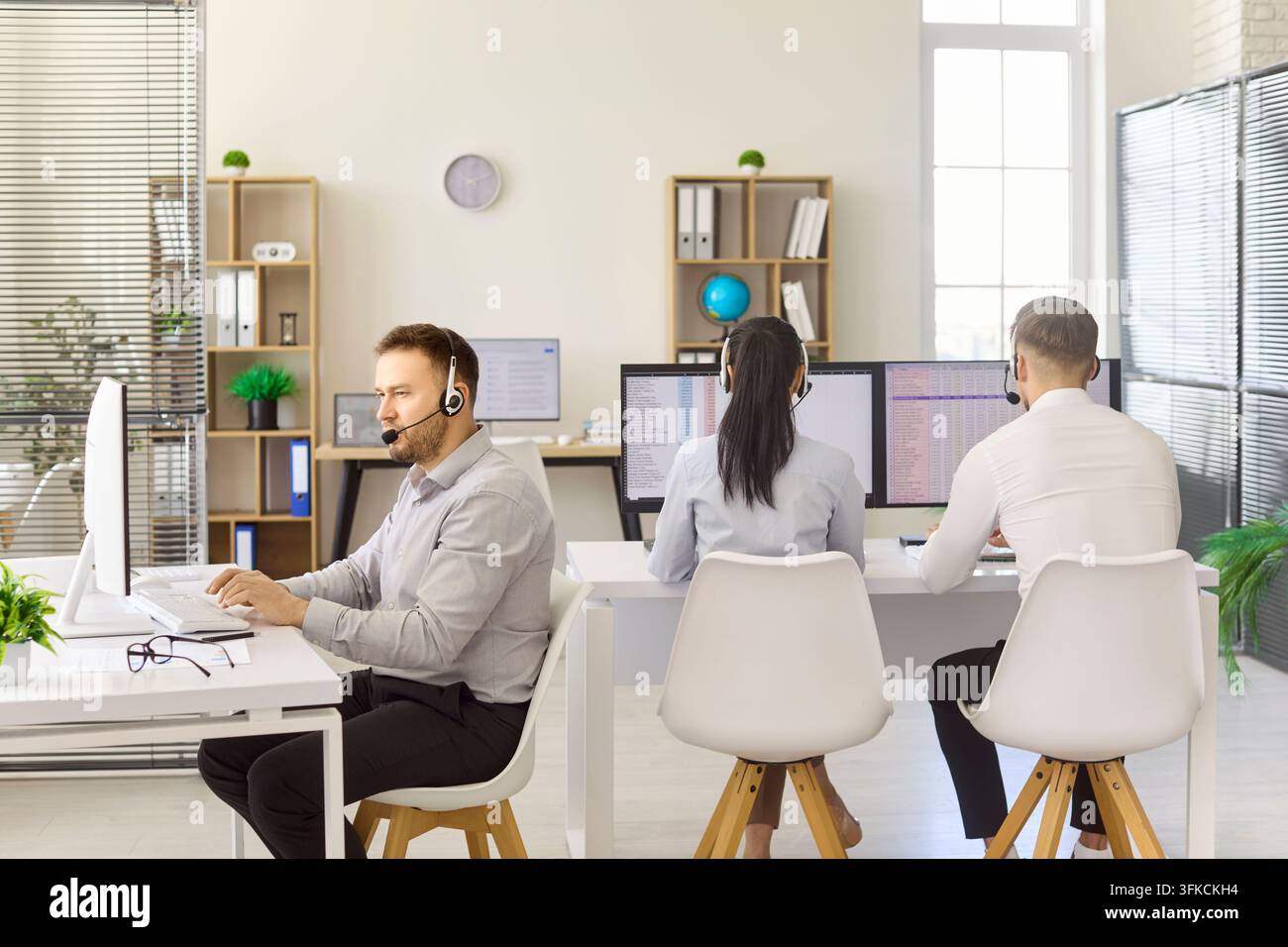 Professionelles Callcenter-Team mit Headsets, das an Desktop-Computern arbeitet Stockfoto