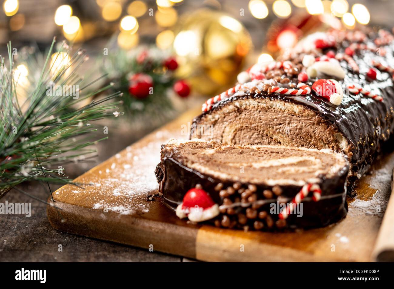 Weihnachts-Schokoladen-Roulade mit Weihnachtslicht-Hintergrund Stockfoto