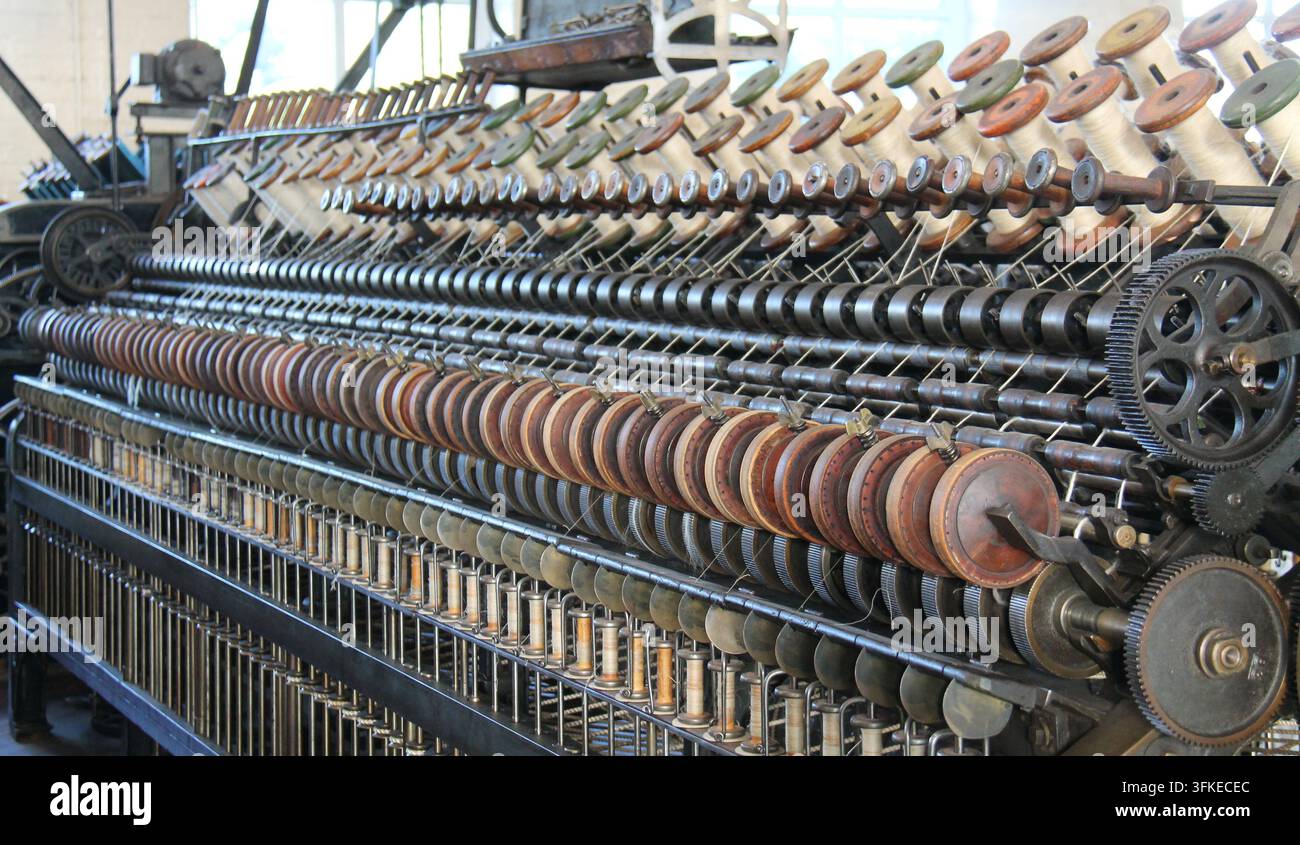 Die Räder und Spulen einer Vintage-Textilmaschine. Stockfoto