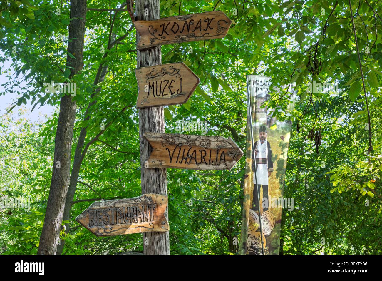 Rustikale Schilder führen Touristen zu einem Museum, einem Weingut, einem Restaurant und einer Lodge innerhalb einer ruhigen Wald-Freizeitanlage. Stockfoto