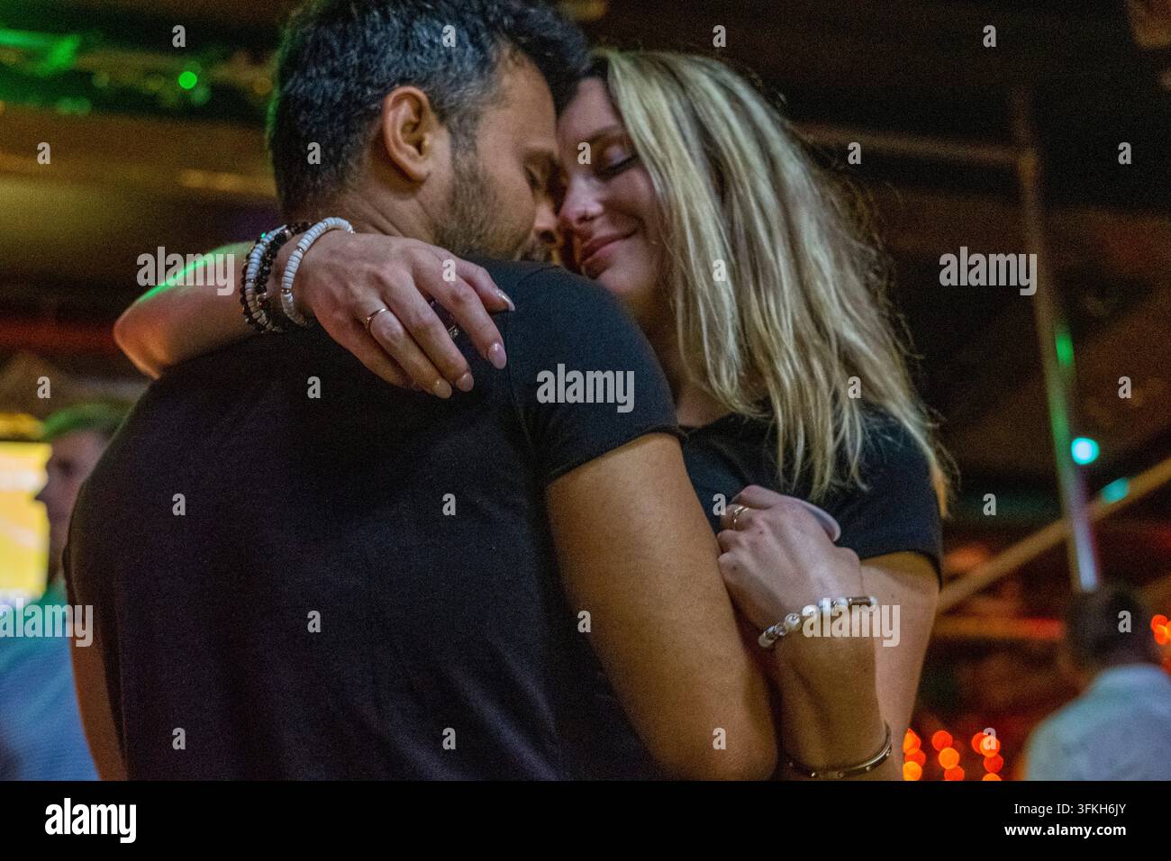 Ein Paar teilt einen zärtlichen und intimen romantischen Moment in einem Nachtclub in Raleigh, North Carolina, USA, am 22. August 2023. Stockfoto