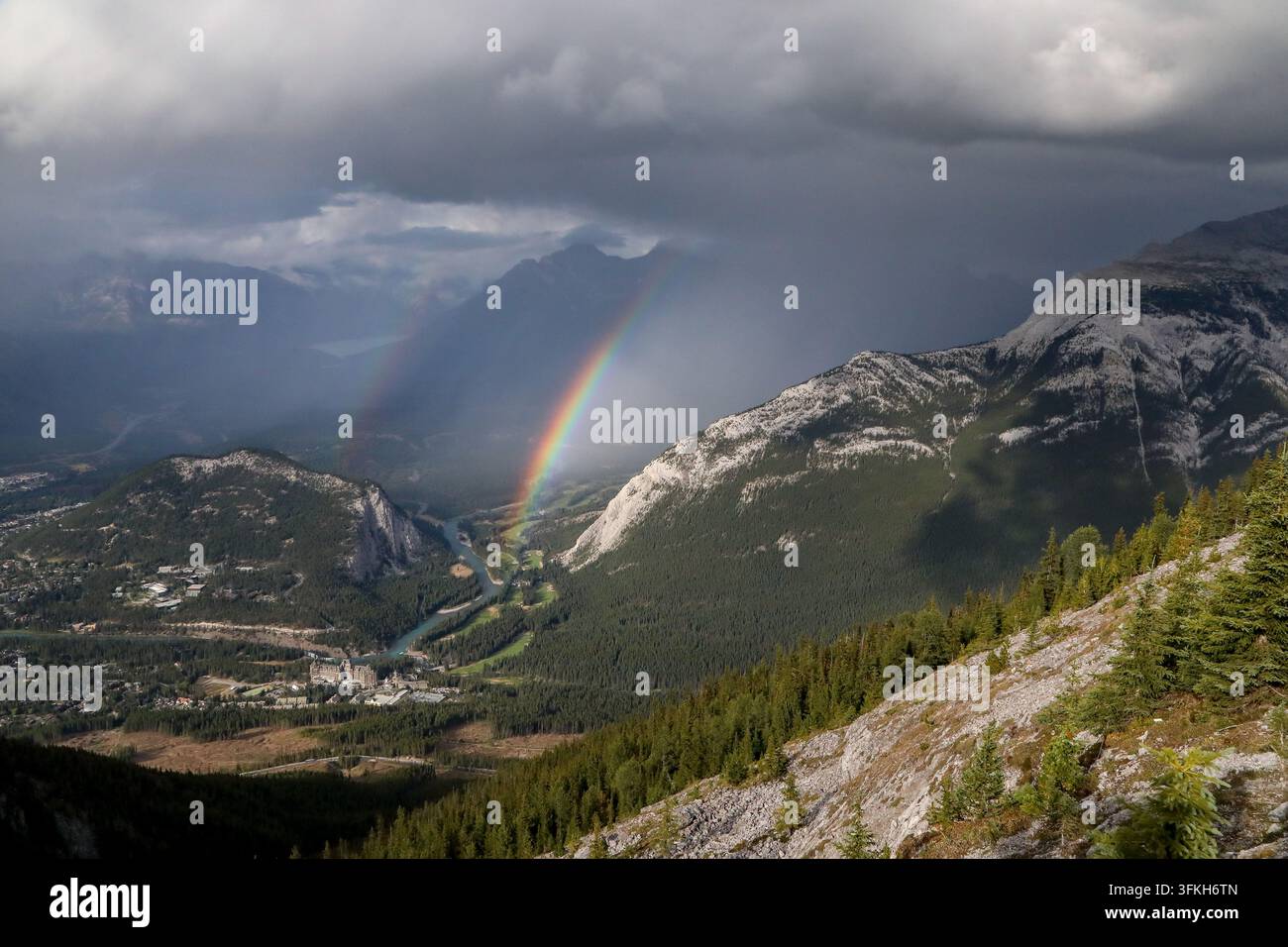 Regenbogen über Rundle - Regenbogen, der zwischen Tunnel Mountain und Mount Rundle entsteht. Banff, Alberta, Kanada Stockfoto