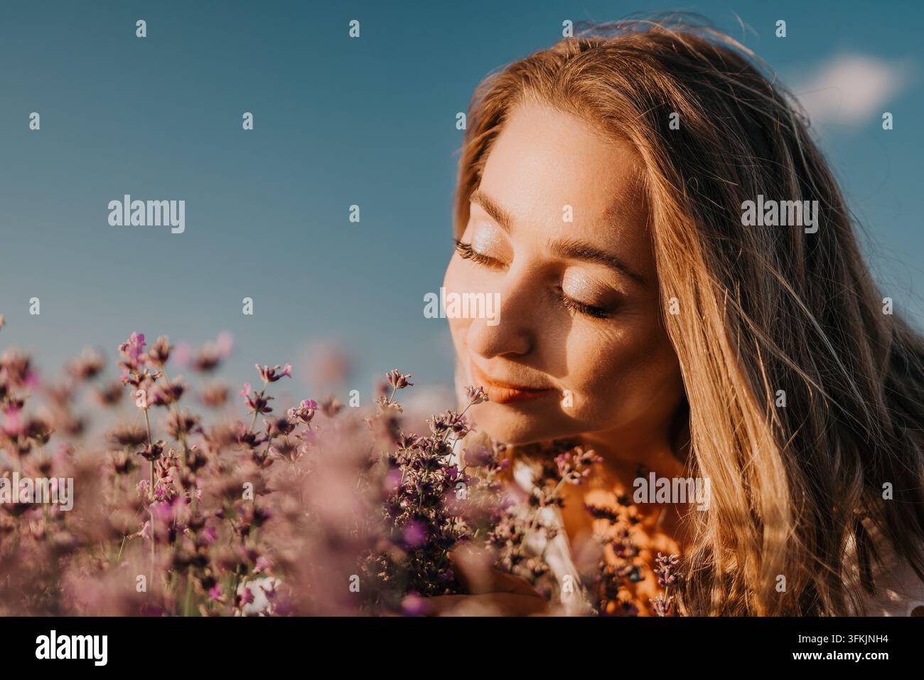 Lavendelfrau auf dem Feld, ruhige Frau genießt den Duft von violetten Lavendelflora in einem sonnigen Sommerfeld mit Kopierraum Stockfoto