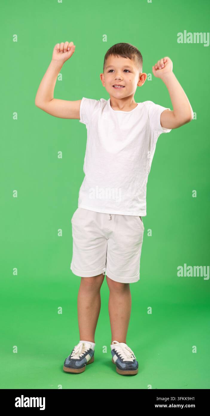 Ein europäisches Kind, ein Junge, ist wirklich glücklich und jubelnd, empfindet ein Gefühl von Freude und Glück, die Person lächelt breit und gestikuliert emotional. Stockfoto