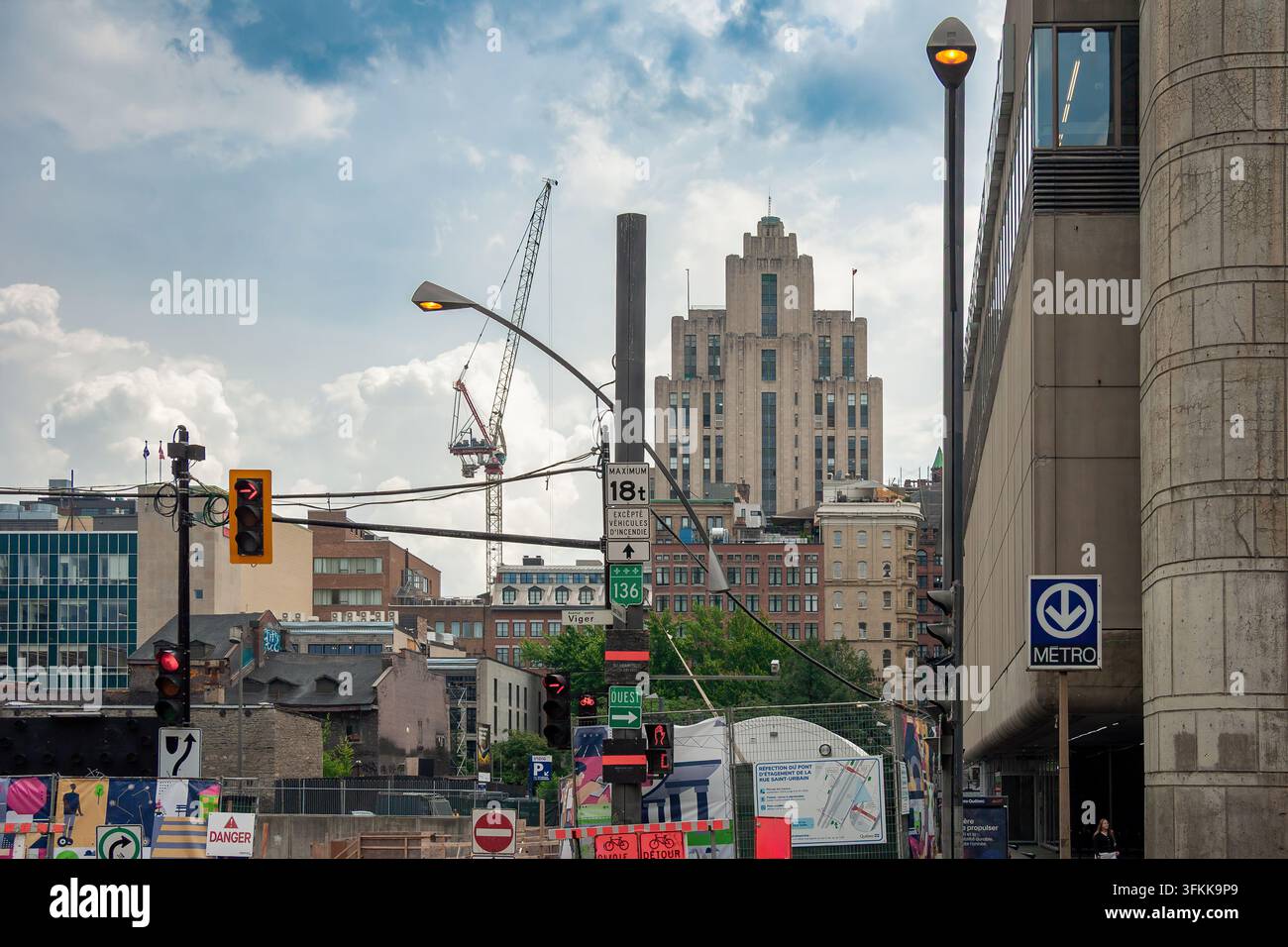 Art Deco Aldred Building Turm mit zurückspringendem Pyramiden-Design hinter einer Stadtstraße, Kränen und Ampeln. Montreal, Quebec, Kanada, Nordamerika Stockfoto