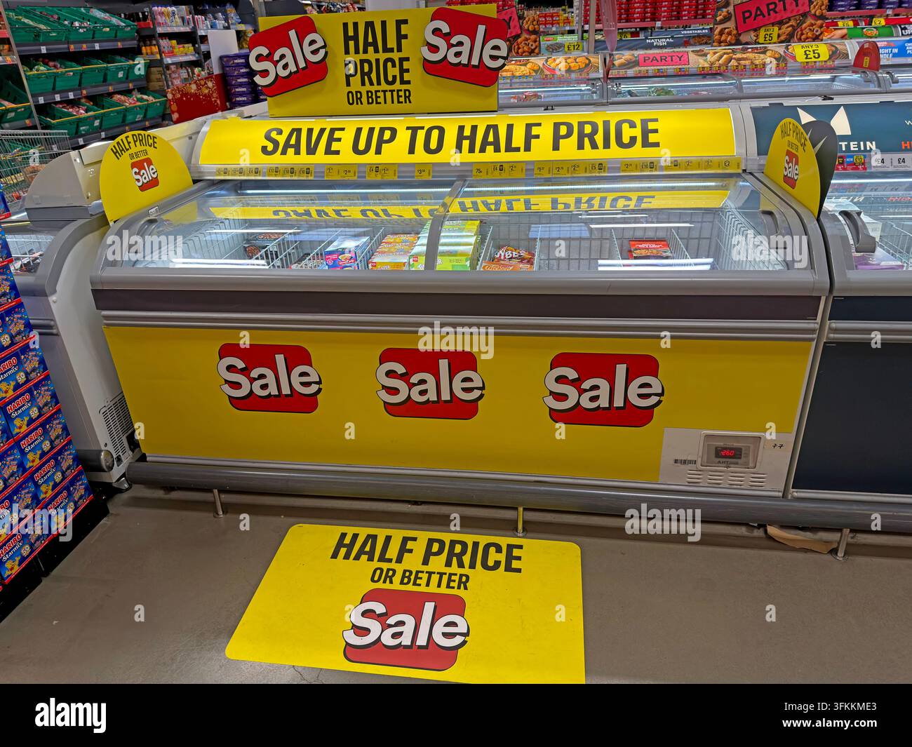 Schilder für einen Halbpreisverkauf an einer Gefriertruhe bei The Food Warehouse von Iceland in Warrington, die den Druck auf Haushalte widerspiegeln, ihre Lebensmittelbudgets zu strecken Stockfoto