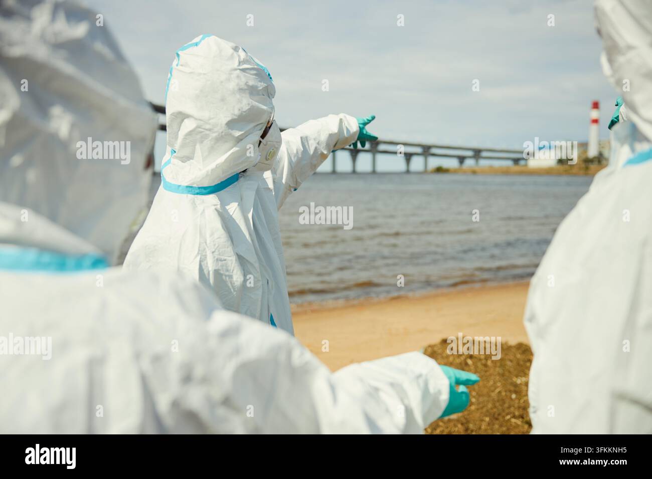 Ökologen in Schutzanzügen inspizieren Wasserverschmutzung im Freien Stockfoto