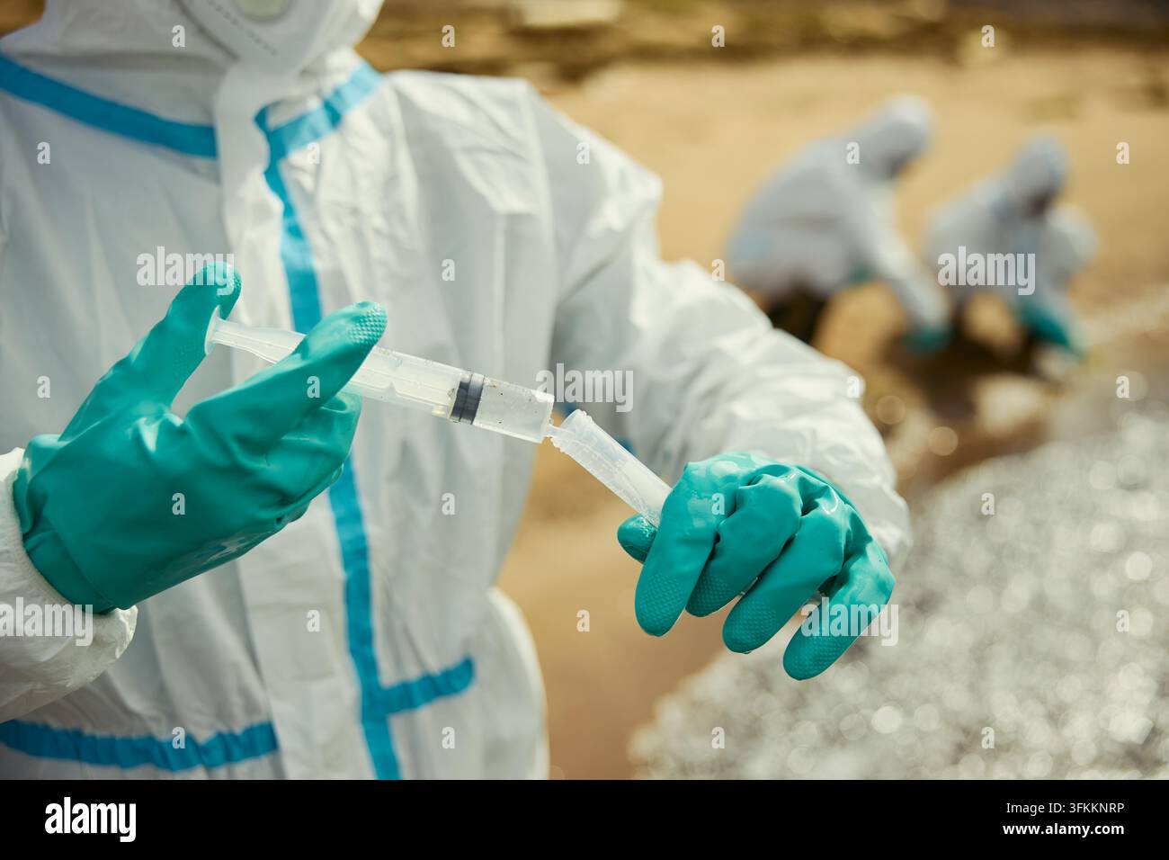 Ökologe in Hazmat-Anzug, der im Freien Wasserproben für die Forschung nimmt Stockfoto