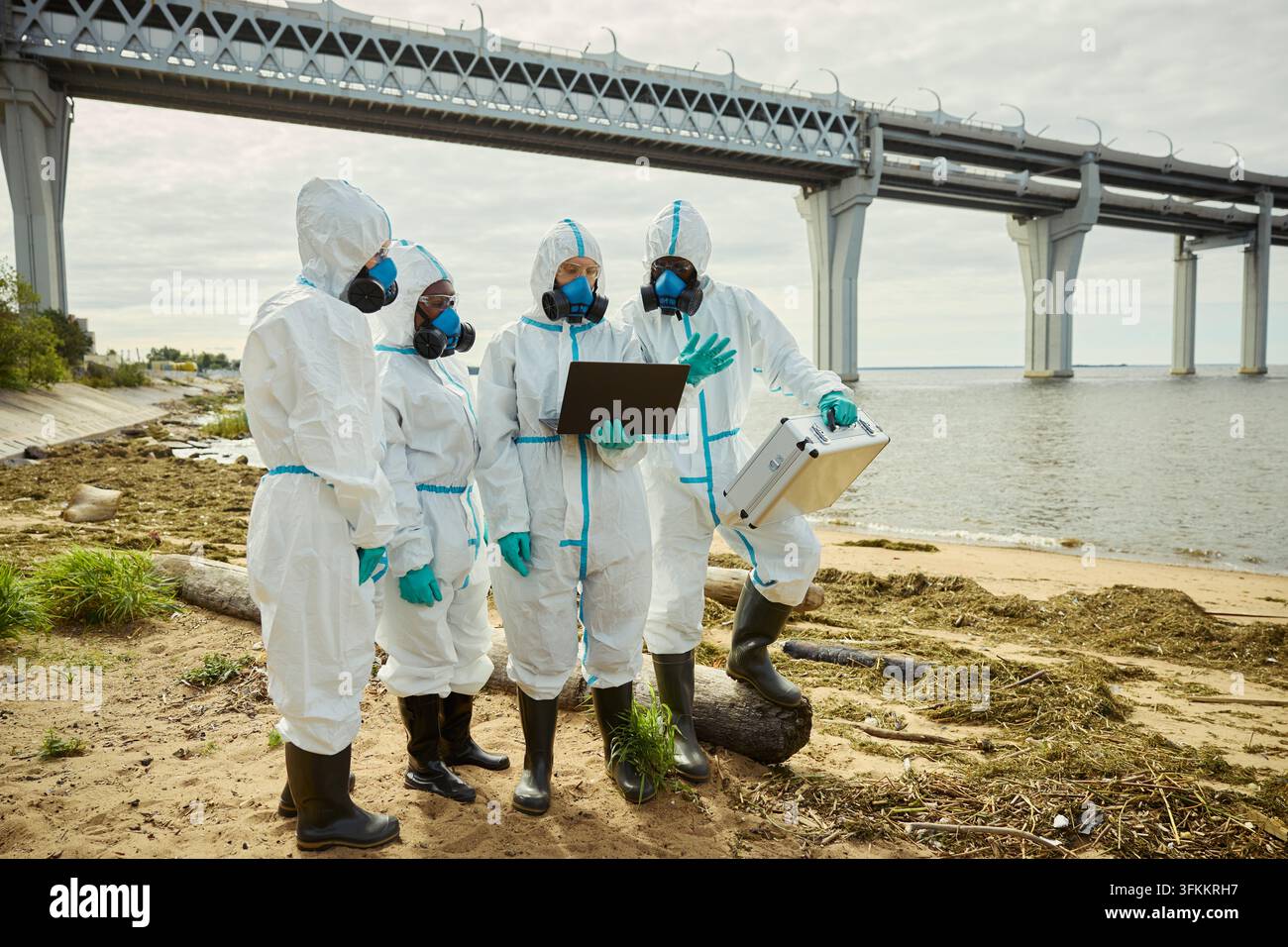 Ökologische Experten in Schutzanzügen überprüfen Daten am Ufer Stockfoto