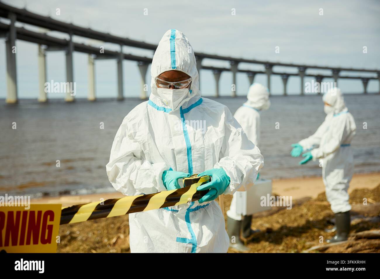 Schwarze Wissenschaftlerin markiert kontaminierten Strandbereich ab Stockfoto