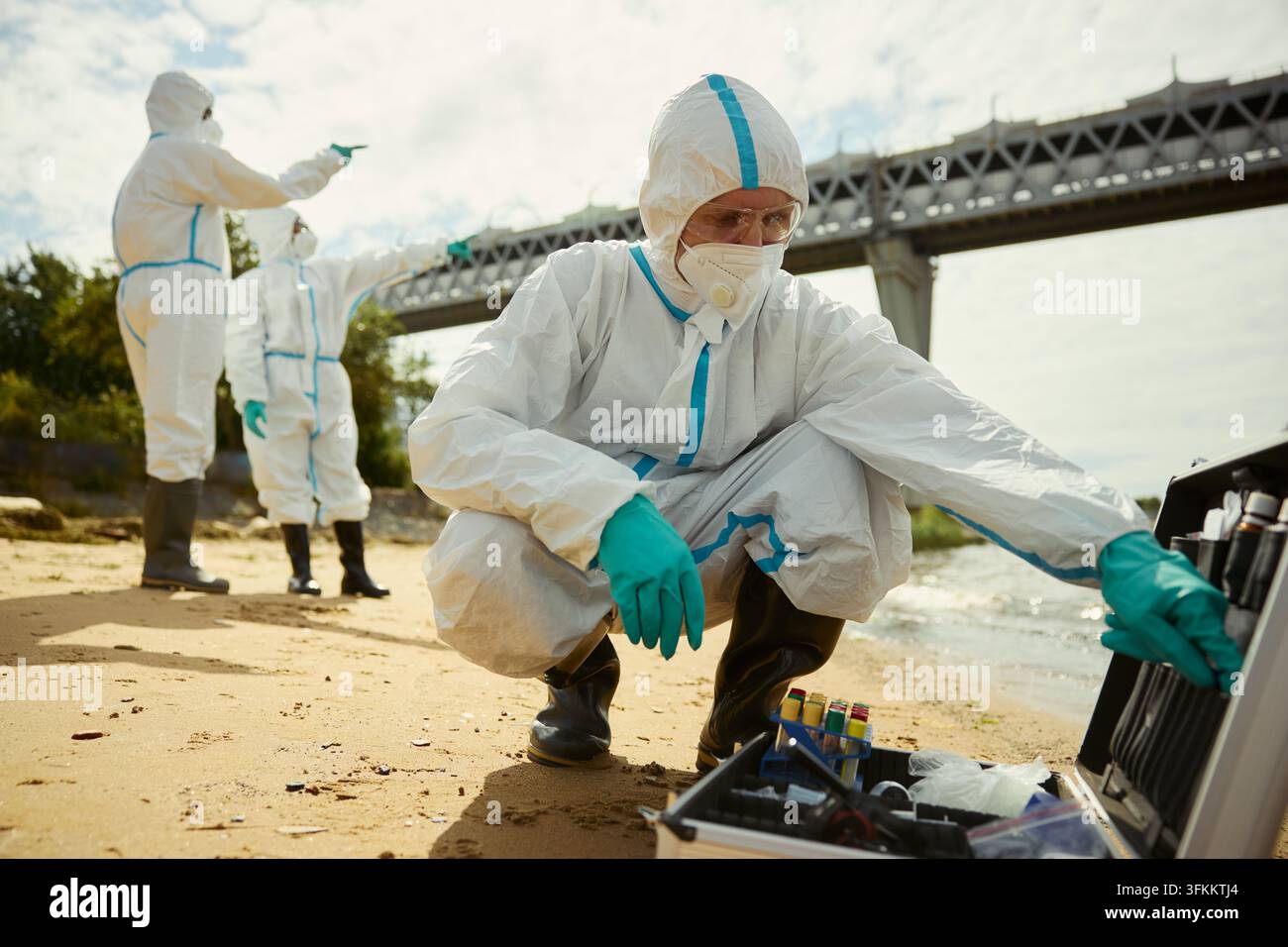 Porträt eines Wissenschaftlers in einem Schutzanzug, der Wasserproben sammelt Stockfoto