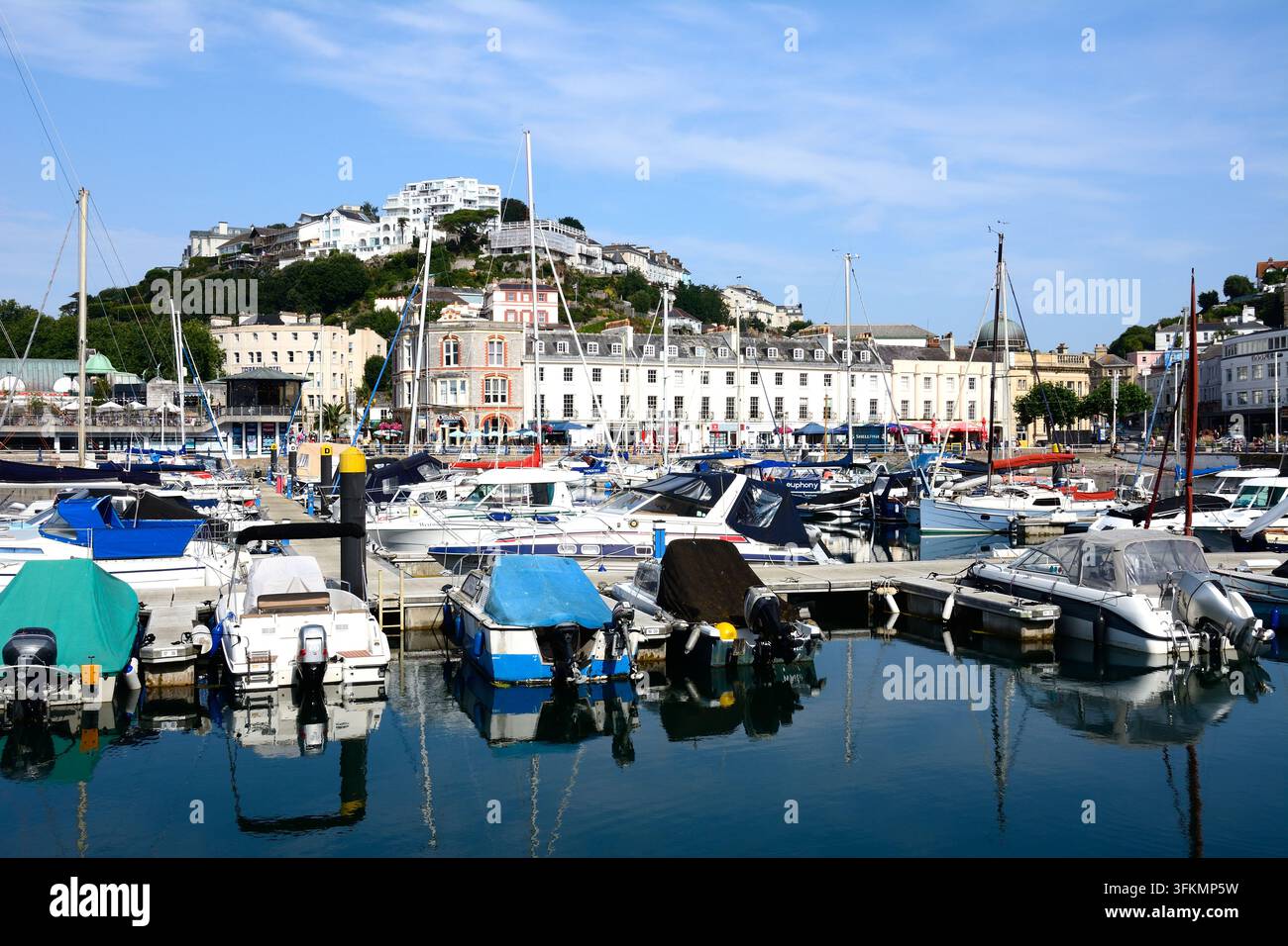 Motorboote und Yachten, die im Yachthafen festgemacht sind, mit Stadtgebäuden im Hintergrund, Torquay, Devon, UK, Europa. Stockfoto