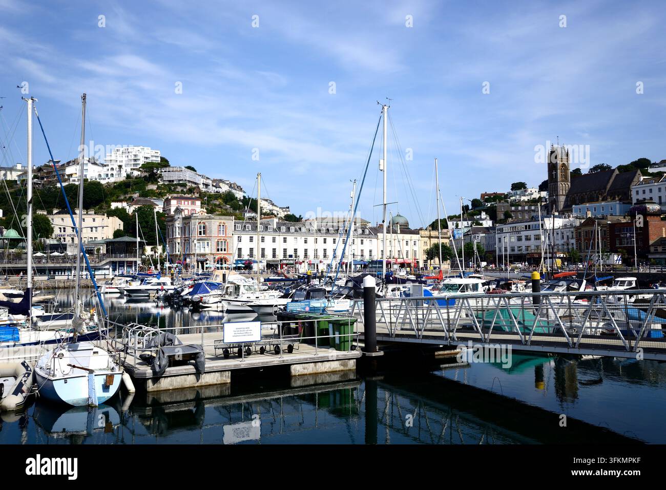 Motorboote und Yachten, die im Yachthafen festgemacht sind, mit Stadtgebäuden im Hintergrund, Torquay, Devon, UK, Europa. Stockfoto