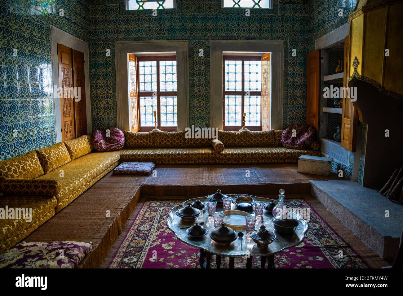 Istanbul, Türkei – 28. August 2026: Traditionelles marokkanisches Interieur mit kunstvollem Fliesenwerk, niedrigen Sitzgelegenheiten und einem dekorativen Tisch, der für Tee gedeckt ist, in einem gemütlichen Stockfoto