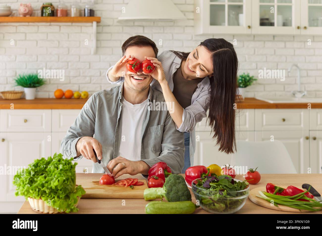 Paar hat Spaß beim Zubereiten gesunder Nahrung mit Gemüse für eine vegane Mahlzeit in der Küche zu Hause. Stockfoto