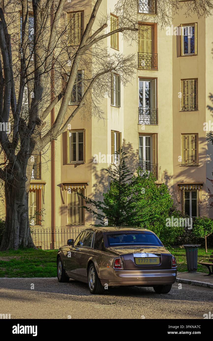 Rolls-Royce Phantom, der in einer eleganten städtischen Gegend geparkt ist, umgeben von Natur Stockfoto